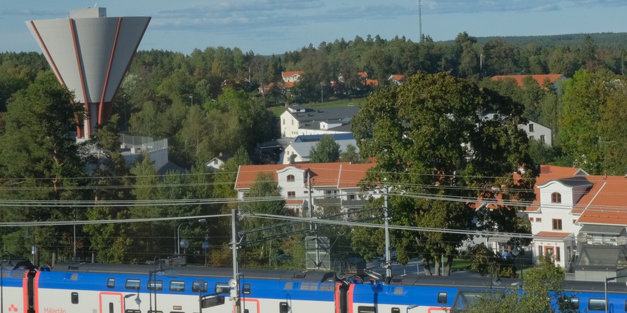 översiktsbild av vattentornet och Bruksparken med ett Mälartåg i förgrunden.